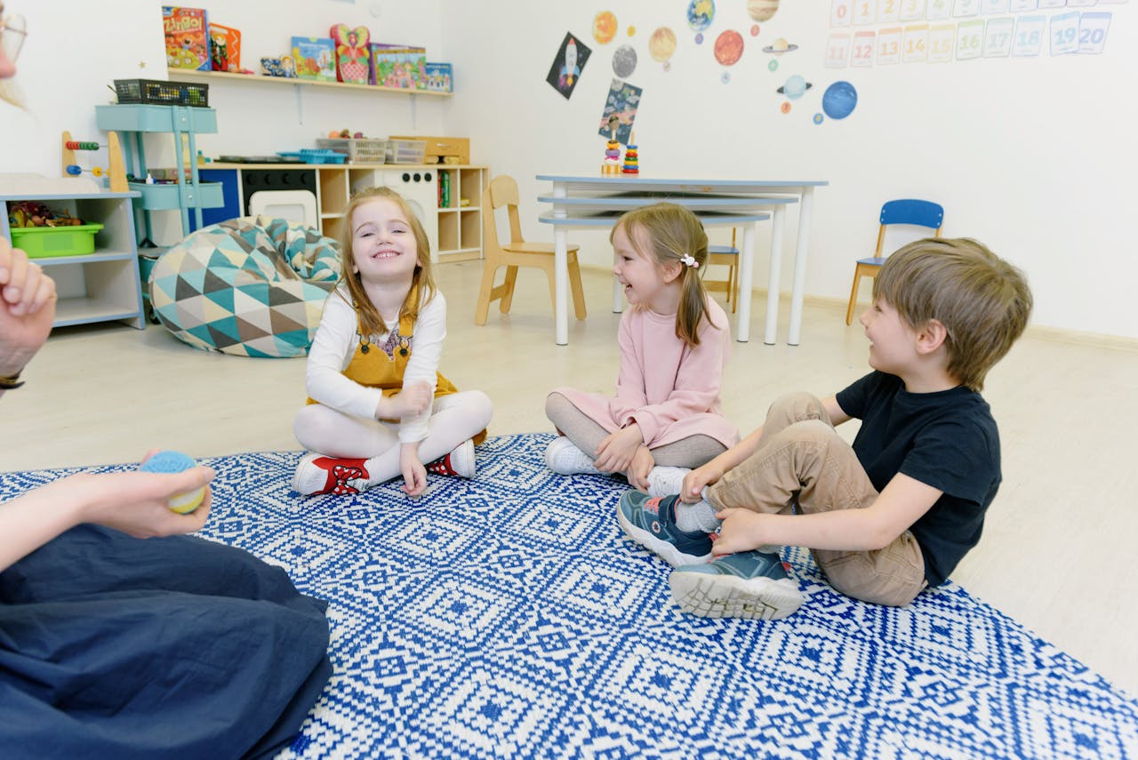services-01 A group of young children happily playing together in a well-decorated kindergarten classroom.